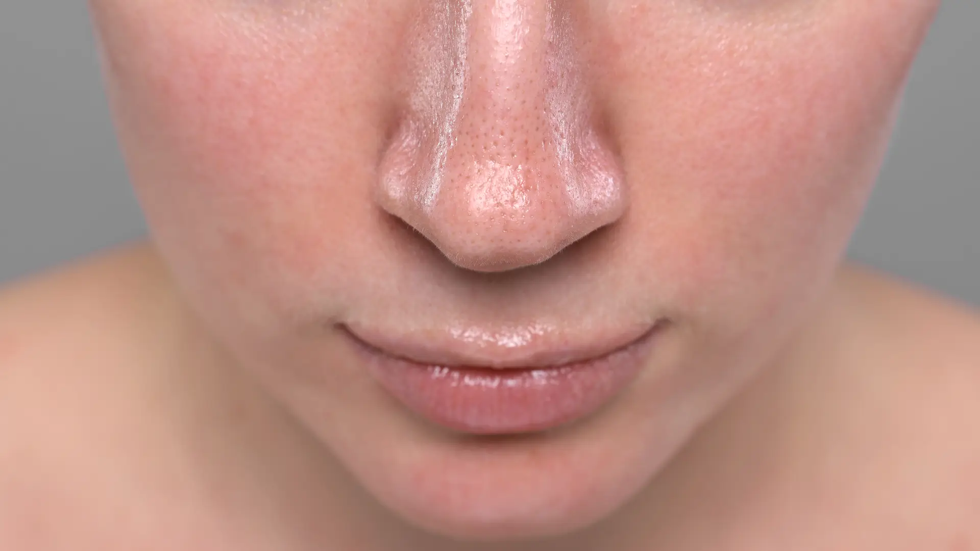 An individual experiencing redness in their facial region.