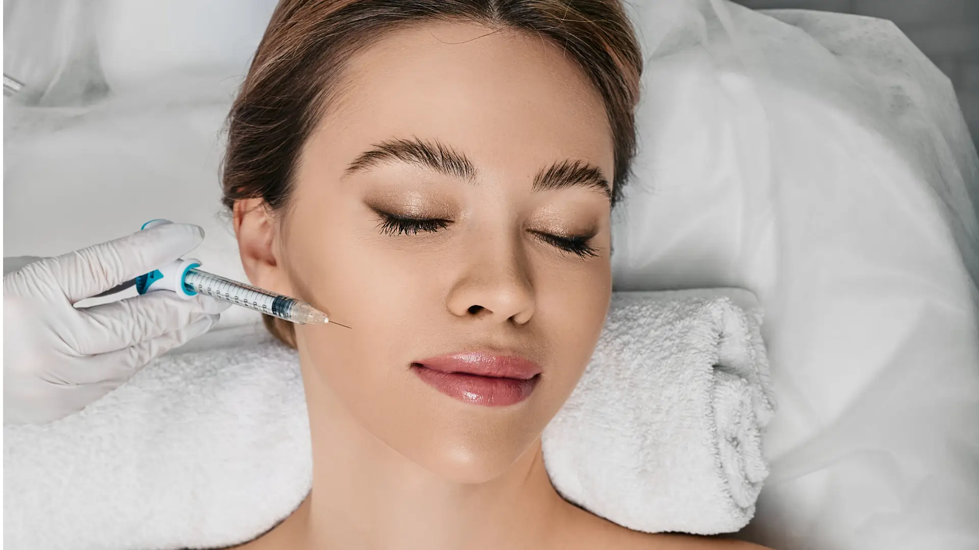 An individual receiving a facial injection for their cheeks.