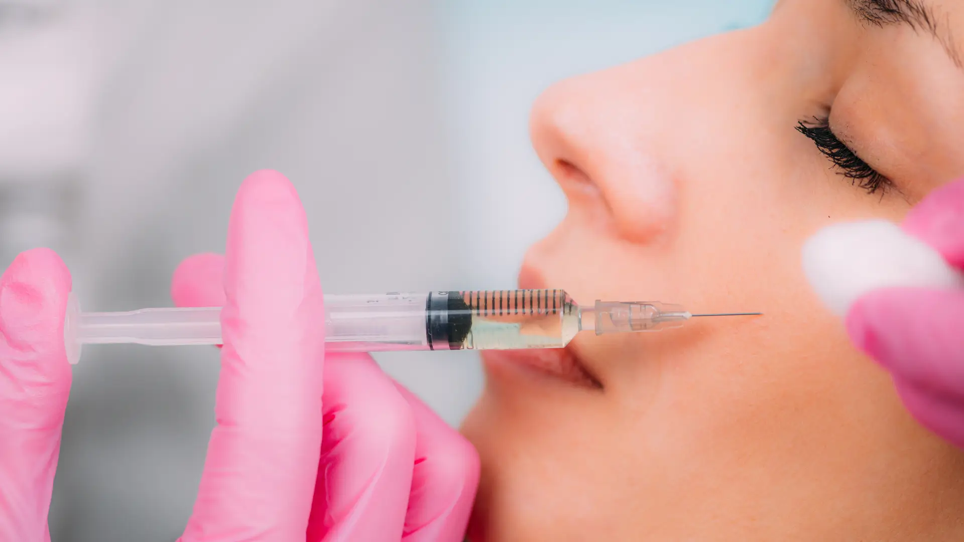 An individual receiving a filler injection for their midface region.