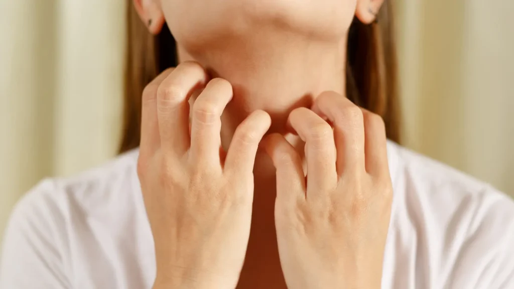 An individual scratching an itchy throat during an allergic reaction.