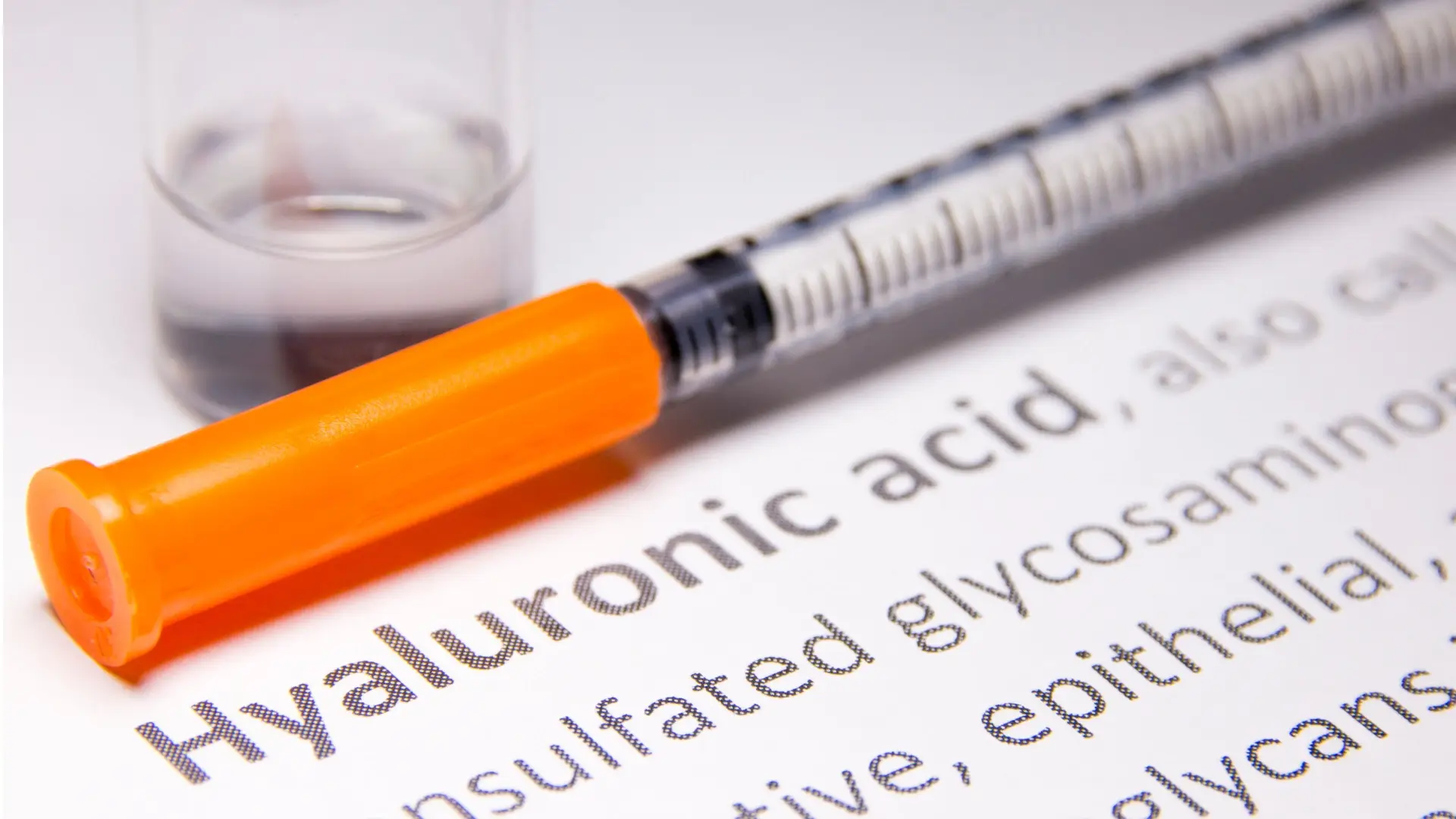 A close-up shot of hyaluronic acid description with a medical syringe.