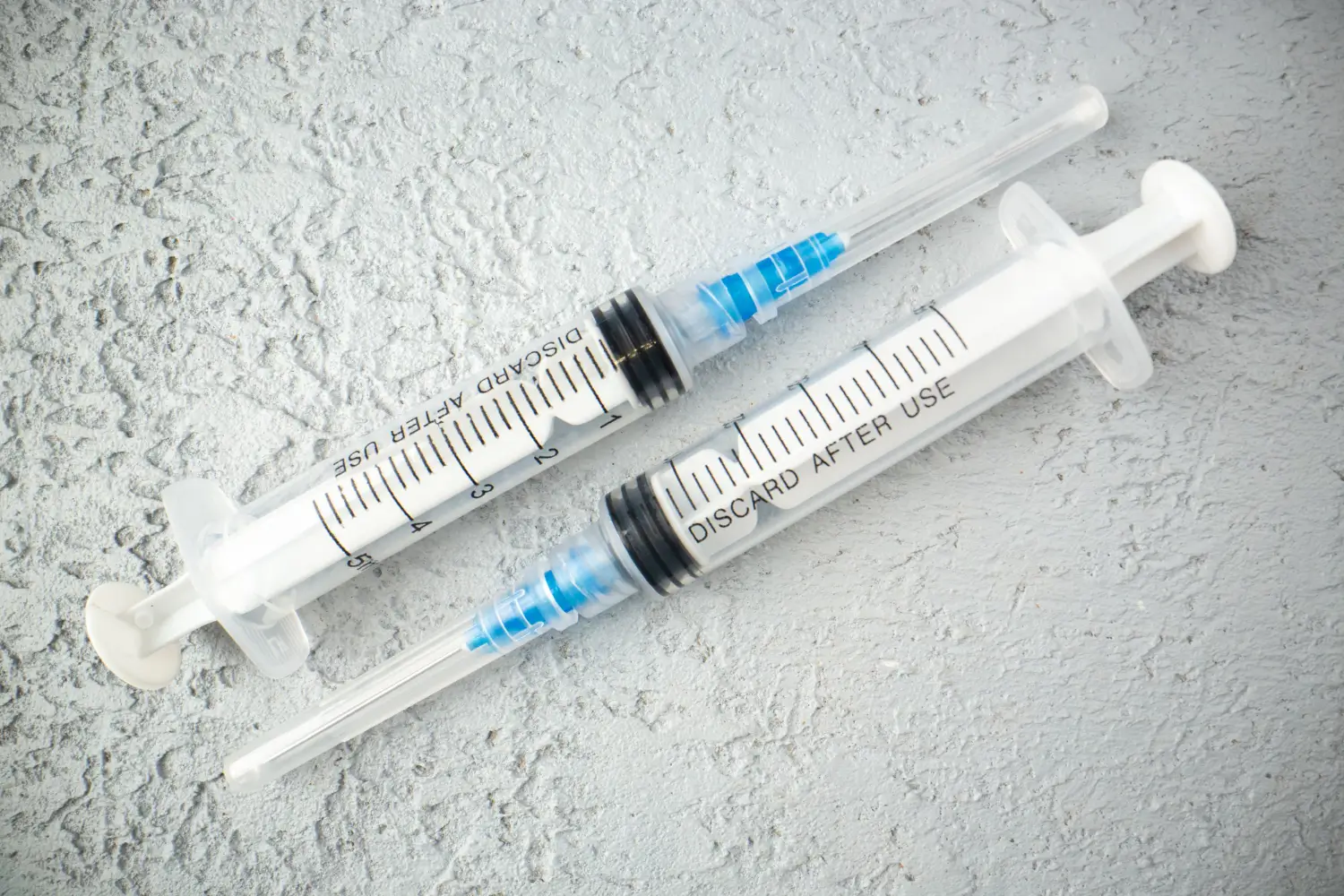 Two empty syringes used for therapeutics or aesthetics.