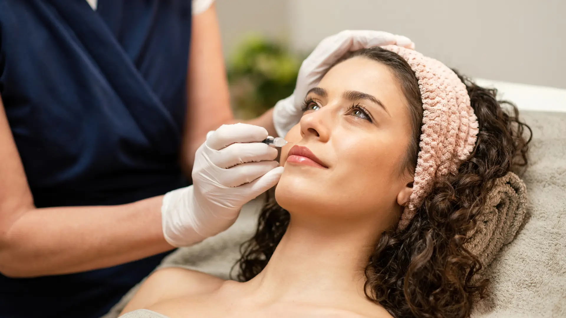 An individual receiving an injection filler into their lip region.