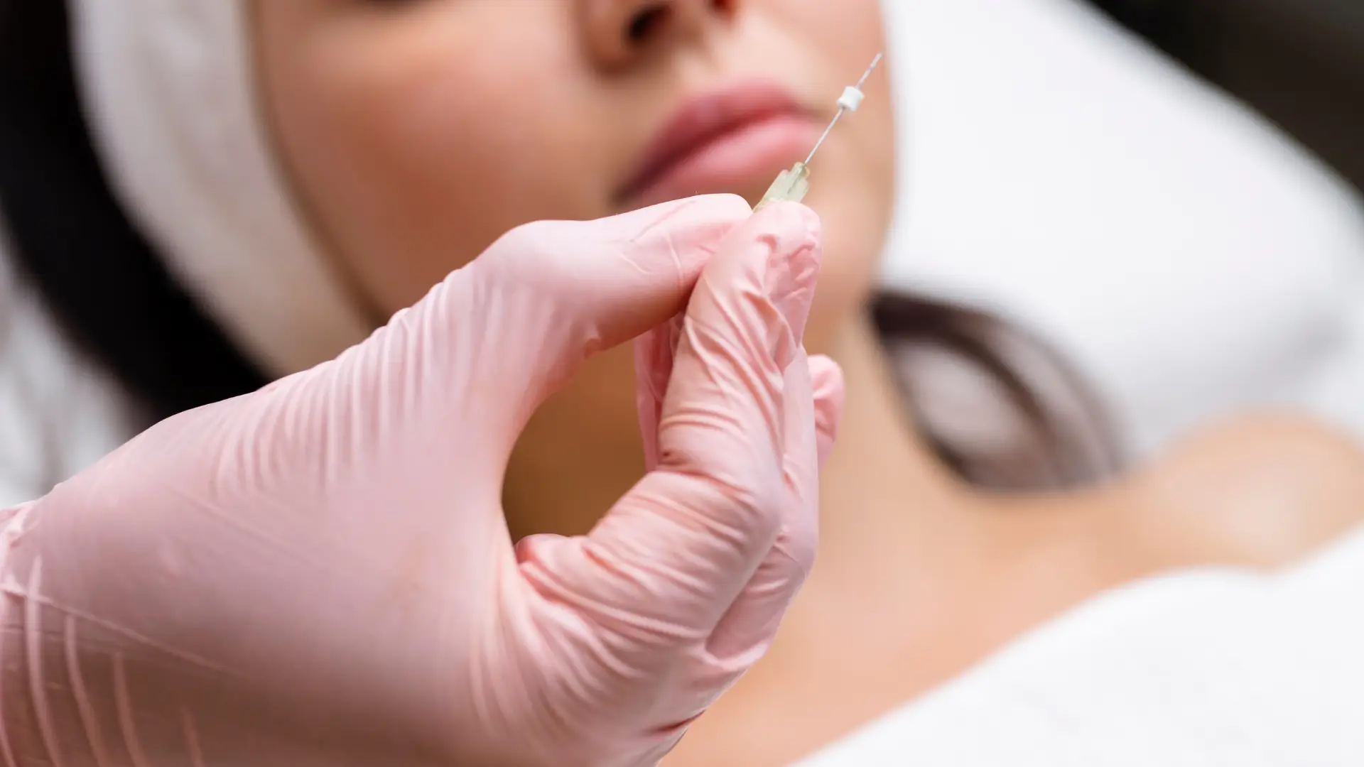 A medical professional holding a thread before administration.