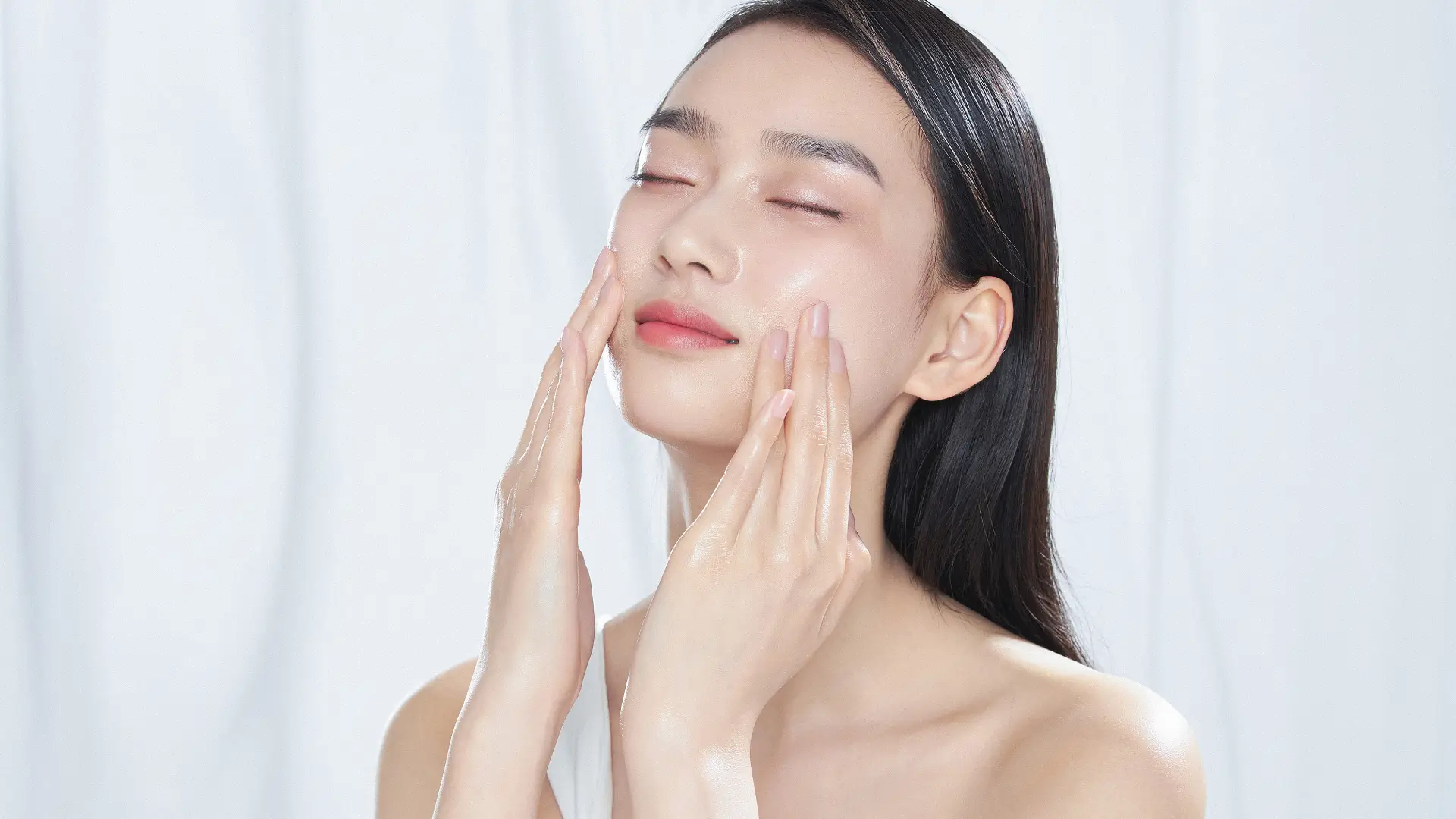 An individual doing their skincare and flaunting their smooth facial skin.