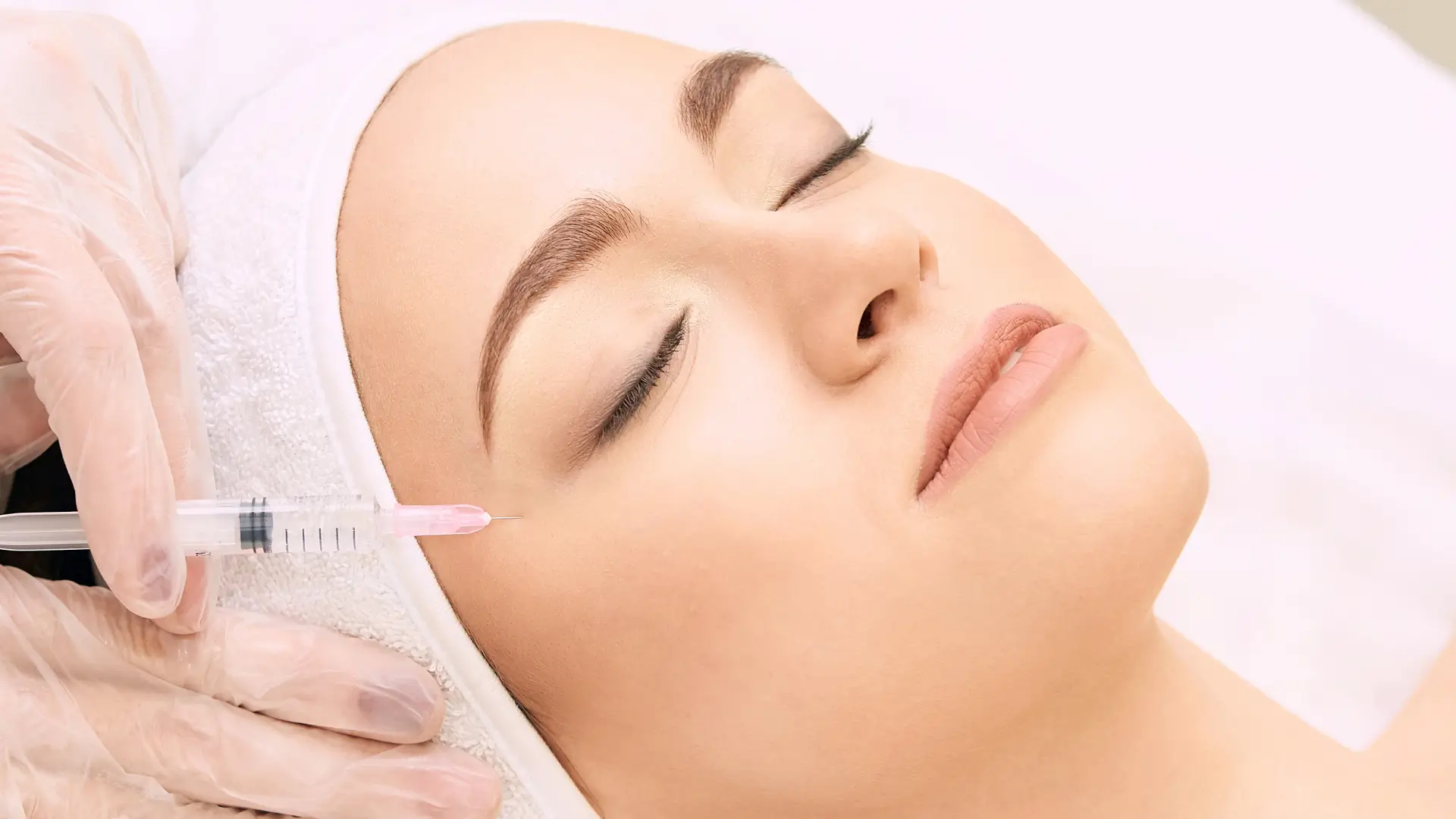An individual receiving an injection for their facial skin.