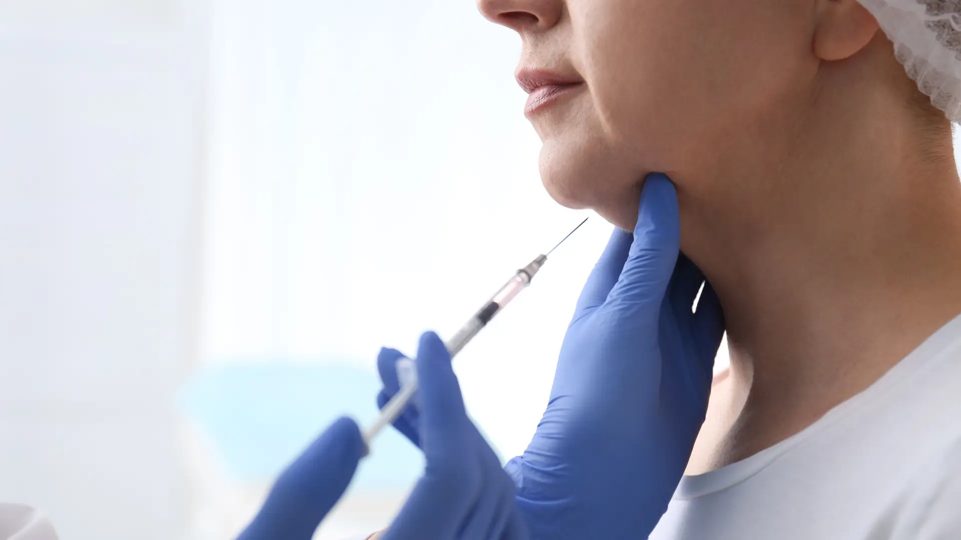 An individual receiving an injection for their chin region.