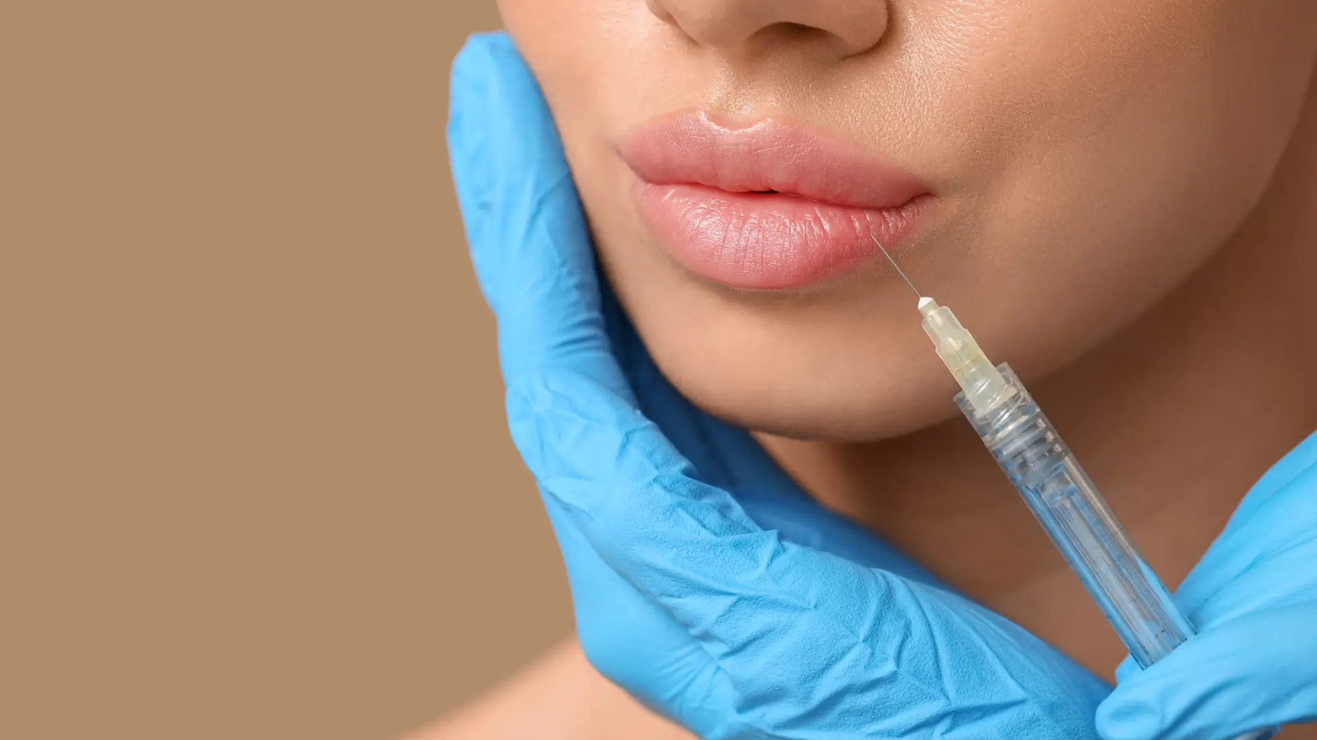 An aesthetic provider administering a lip injection into a patient.