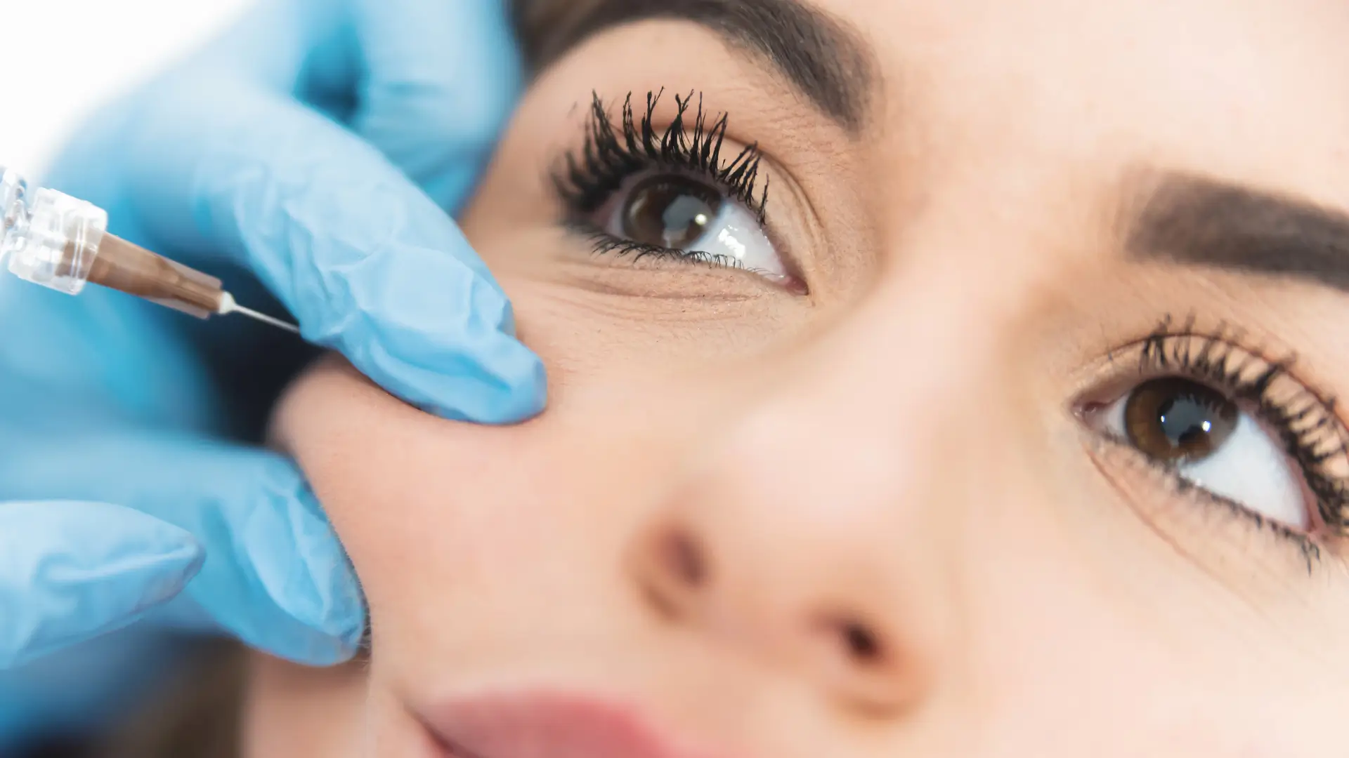 An individual receiving an injection in their cheek region.