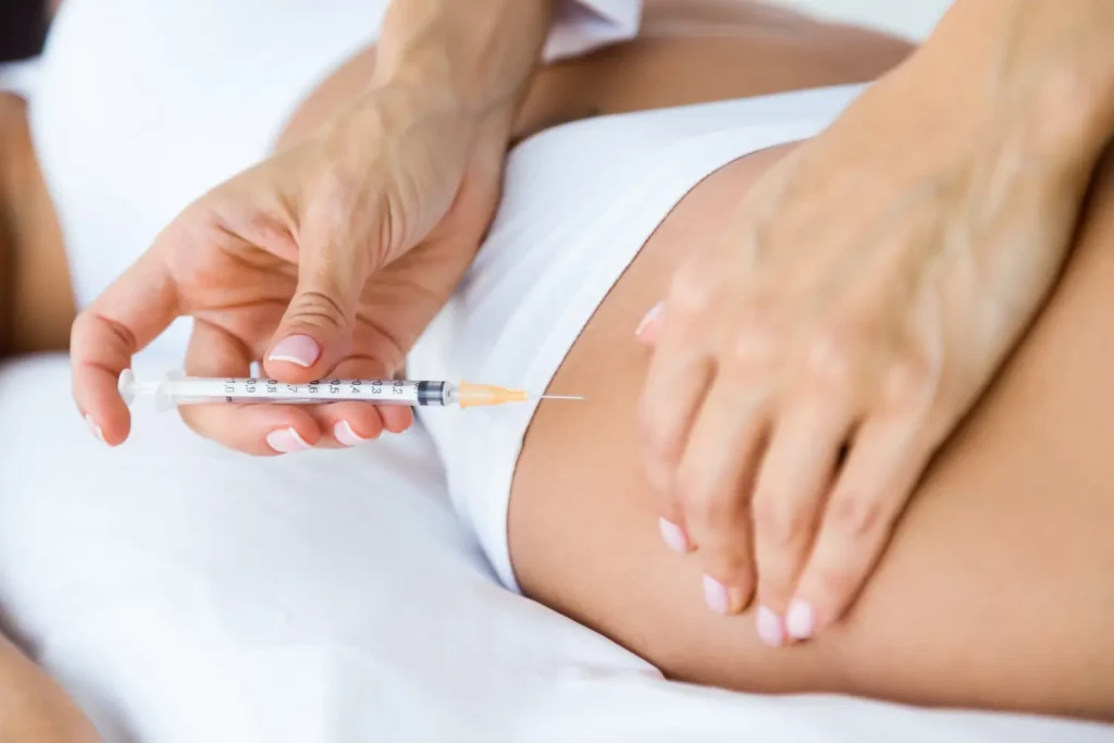 An individual receiving an injection on their upper thigh.