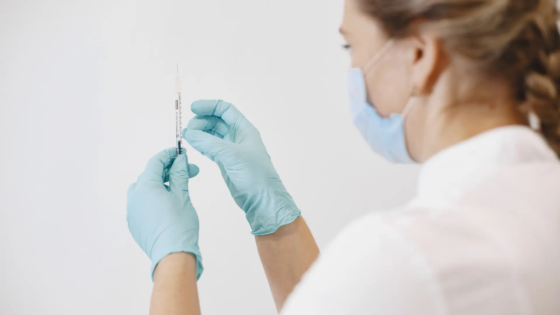 A medical professional preparing a syringe.
