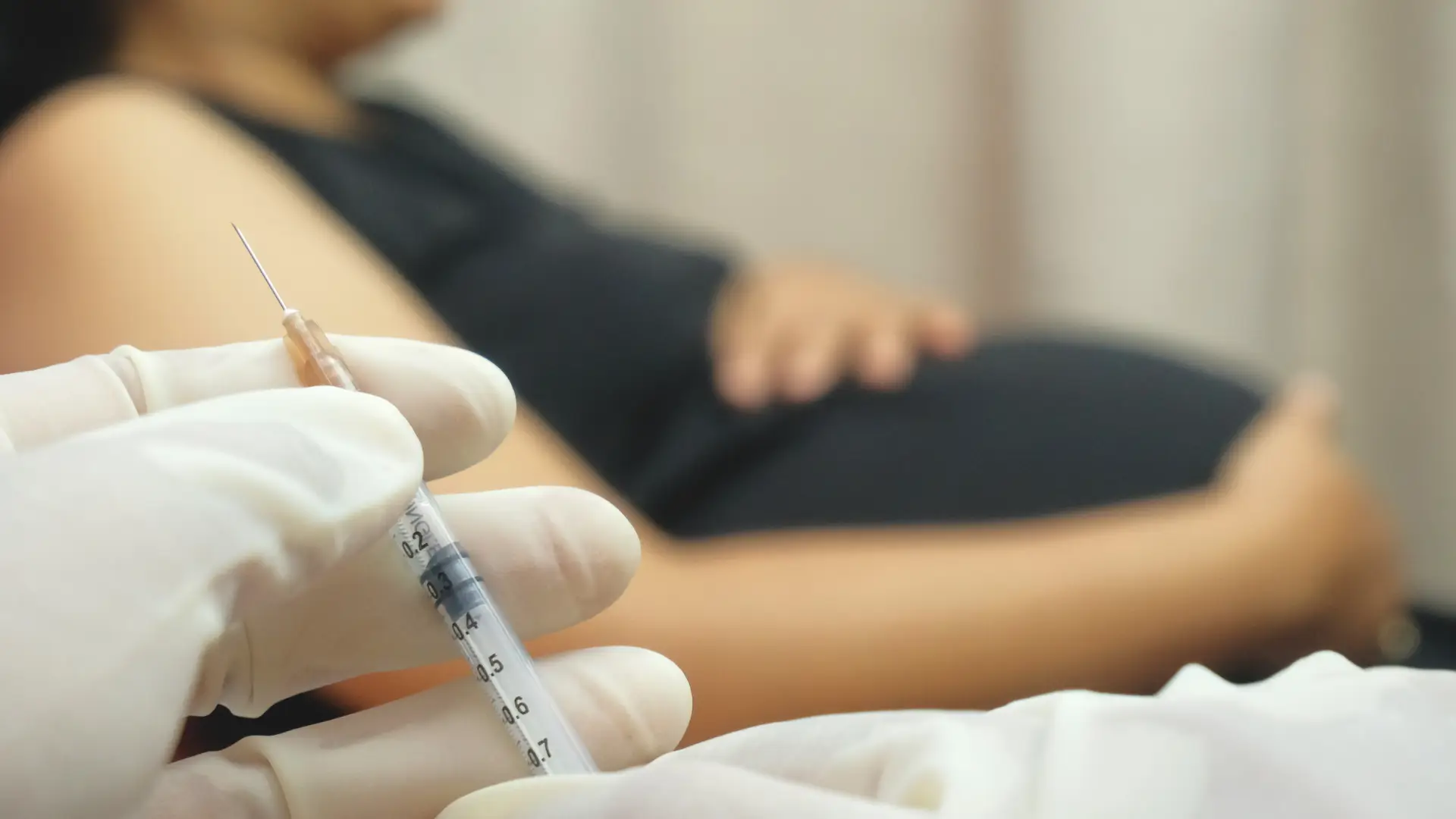 A pregnant woman preparing for their injection treatment.