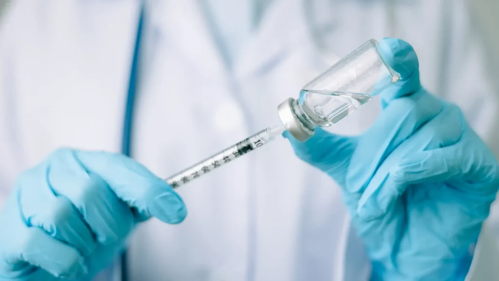 A medical professional preparing an injection.