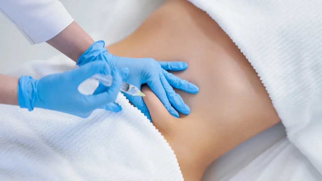 An individual receiving an injection into their abdomen region.