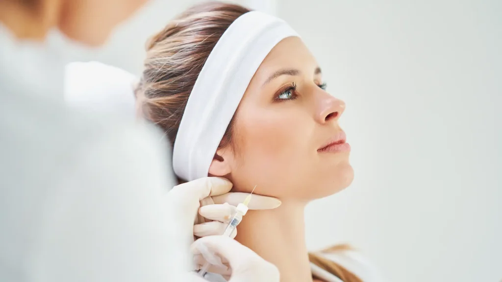 An individual receiving an injection for their lower face region.