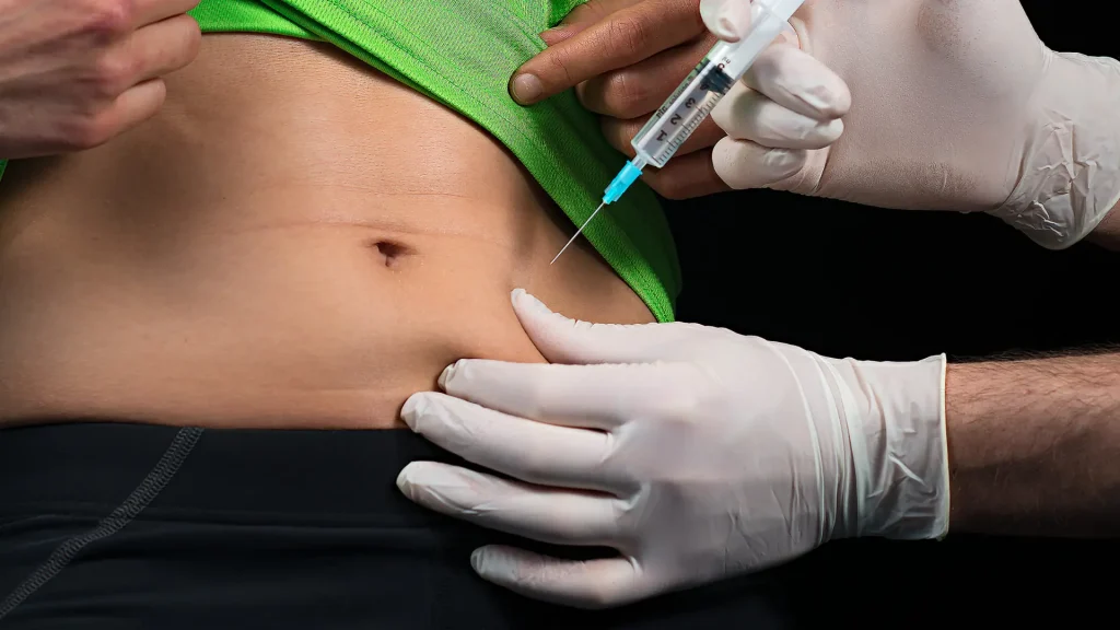 A medical professional administering an injection into a patient's abdomen.