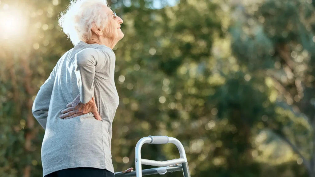 An older woman happily walking with assistance and their improved osteopororis condition.
