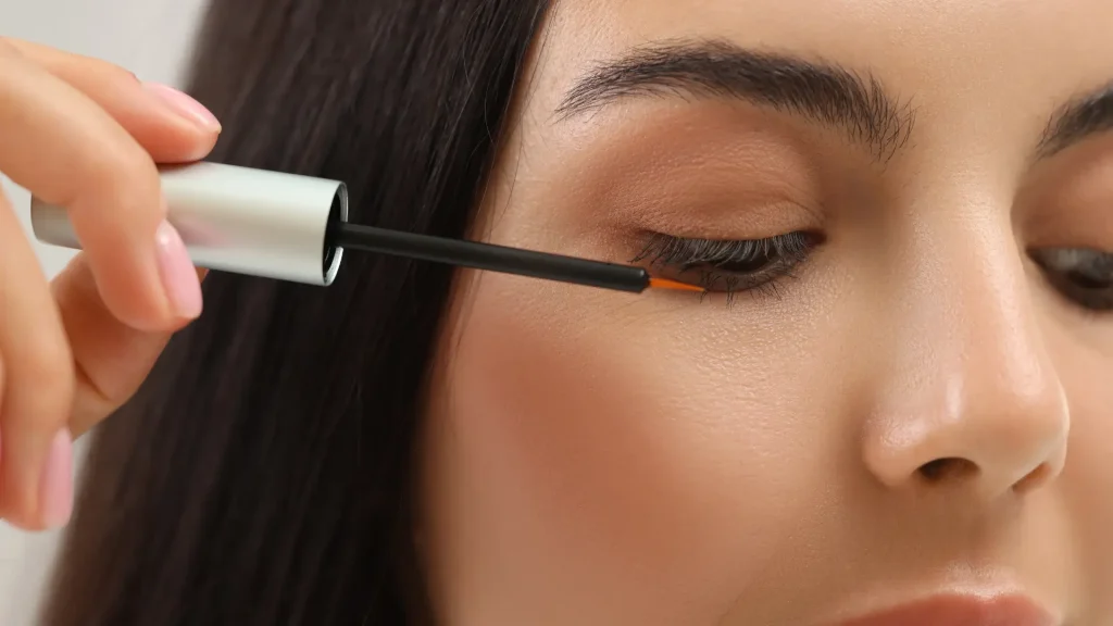 An individual applying a serum for their eyelashes.