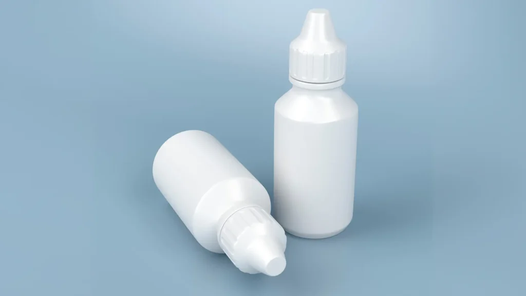 Two eyedrop bottles on a surface.