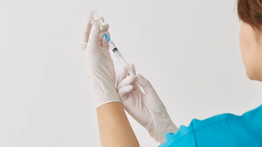 A medical professional preparing an injection.