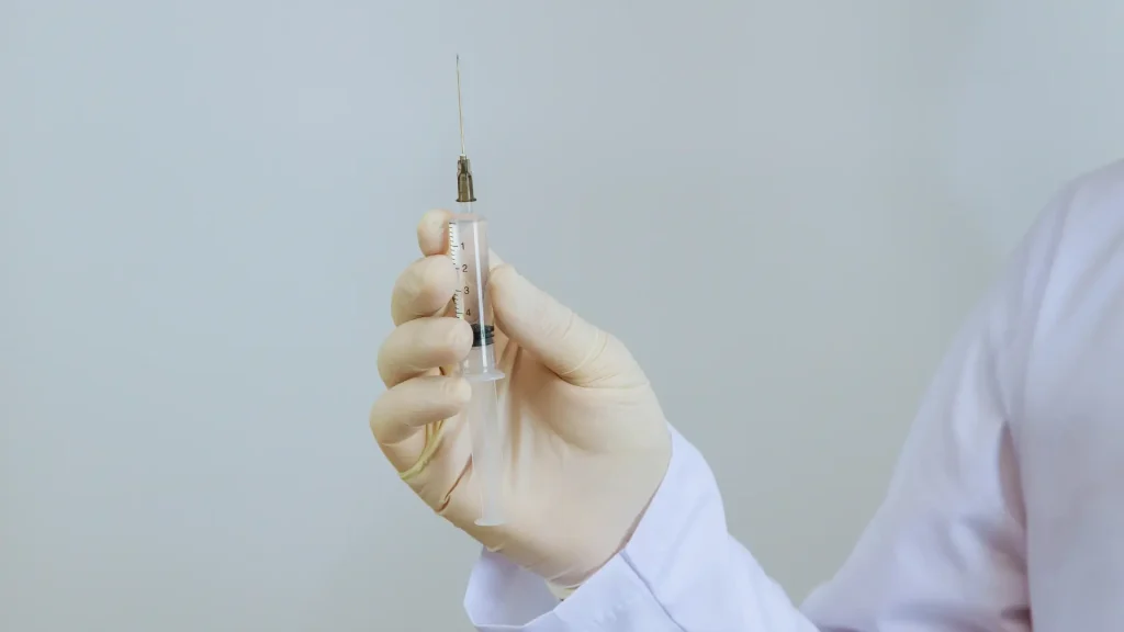 A medical professional holding a syringe.