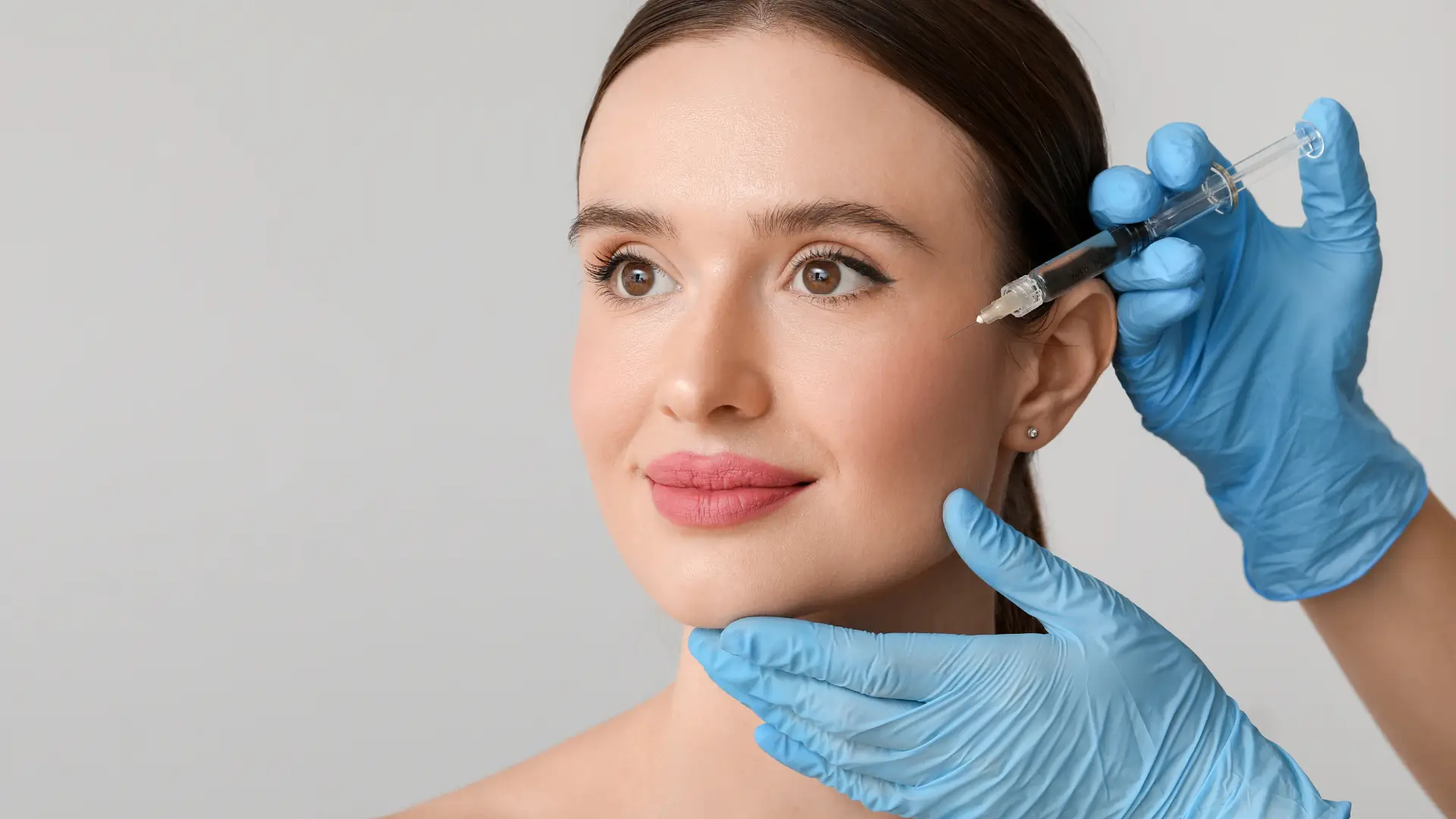 An individual receiving an injection for their facial skin.