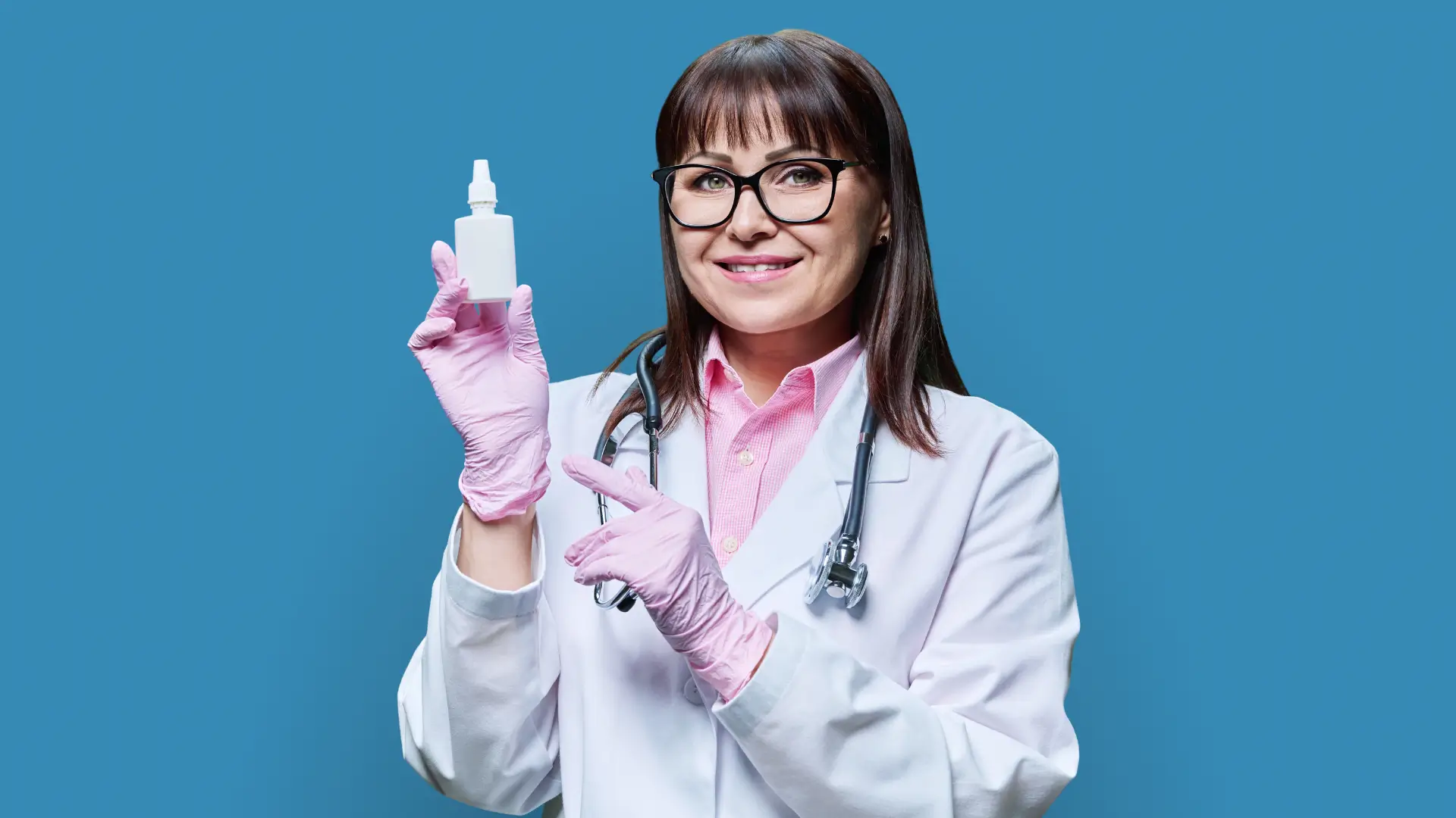 A medical professional holding a medicine drops.