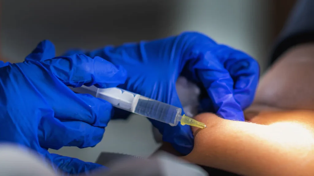 An individual receiving an injection into their abdomen.