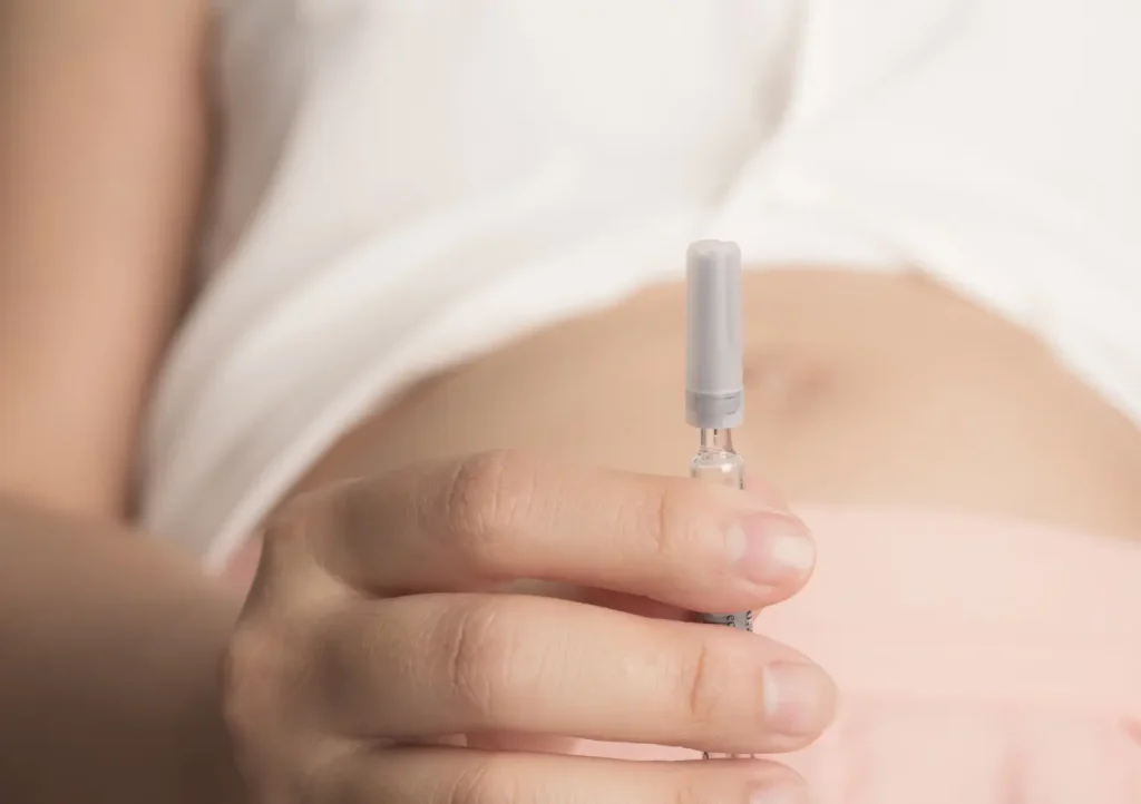 An individual holding a medical syringe.