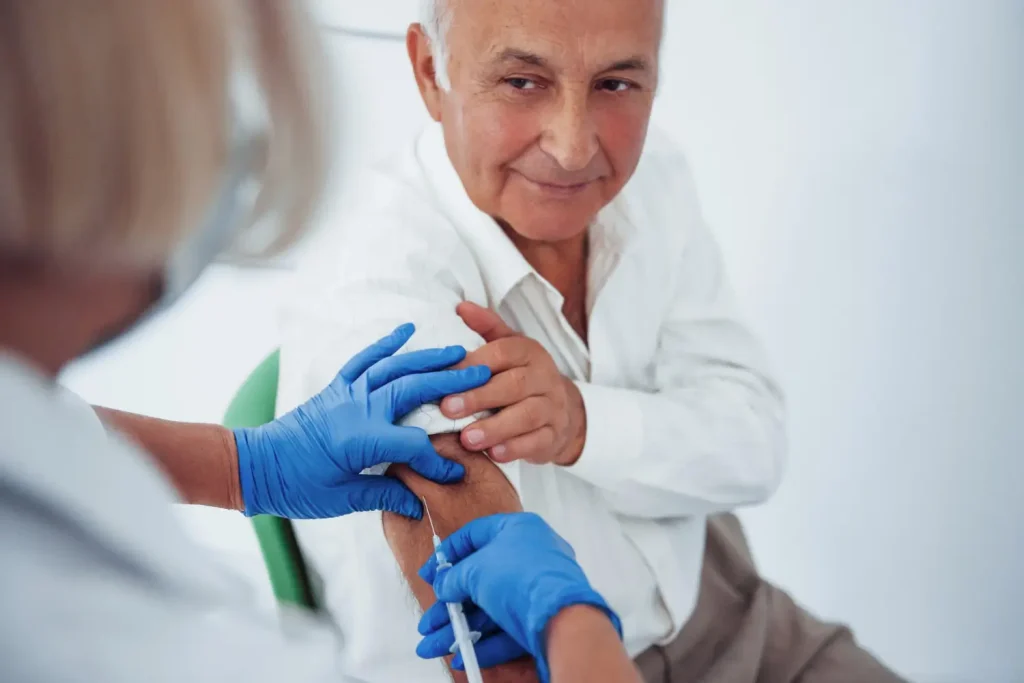 An individual receiving an injection in their upper arm.