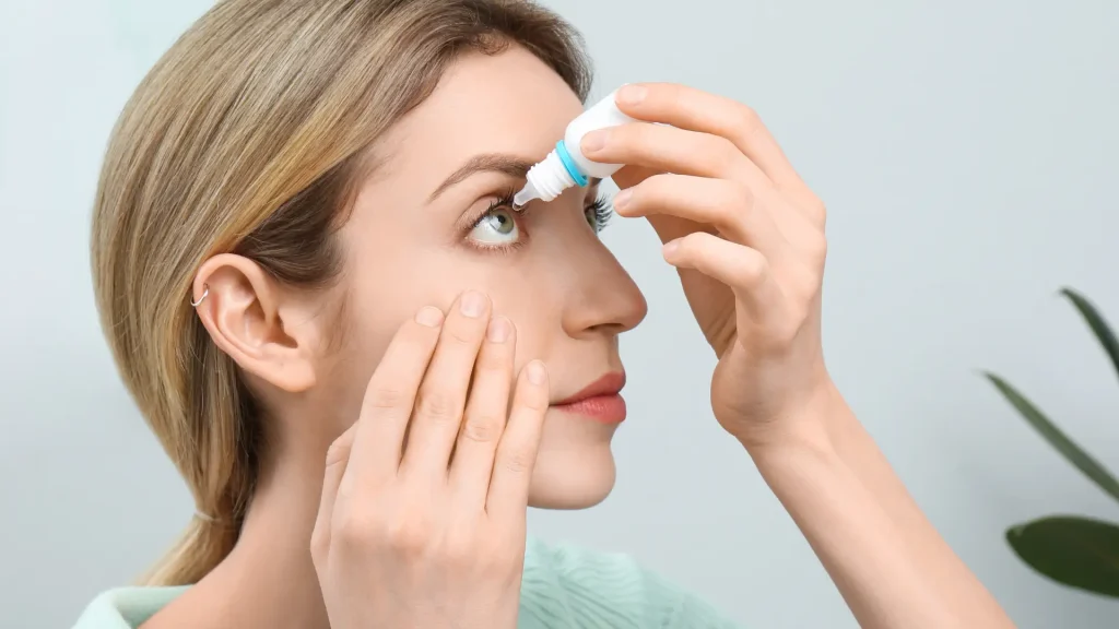An individual applying a drop of eye solution for their eyes.