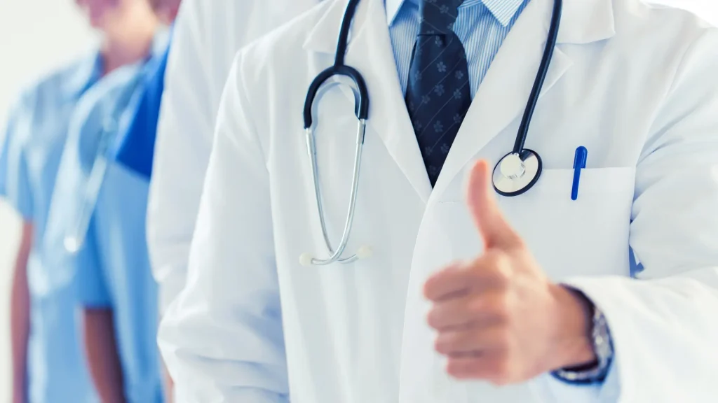 A doctor posing a thumbs up due to an approved treatment.