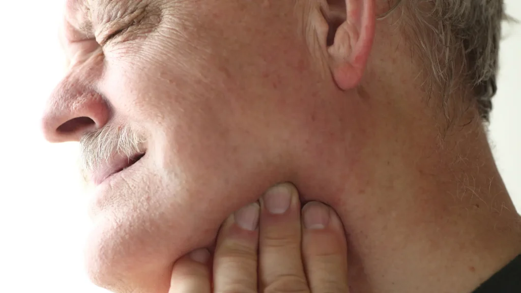 An older individual dealing with jaw pain.