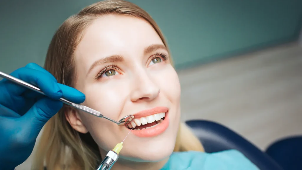 A medical professional injecting a formulation into a patient's gums.
