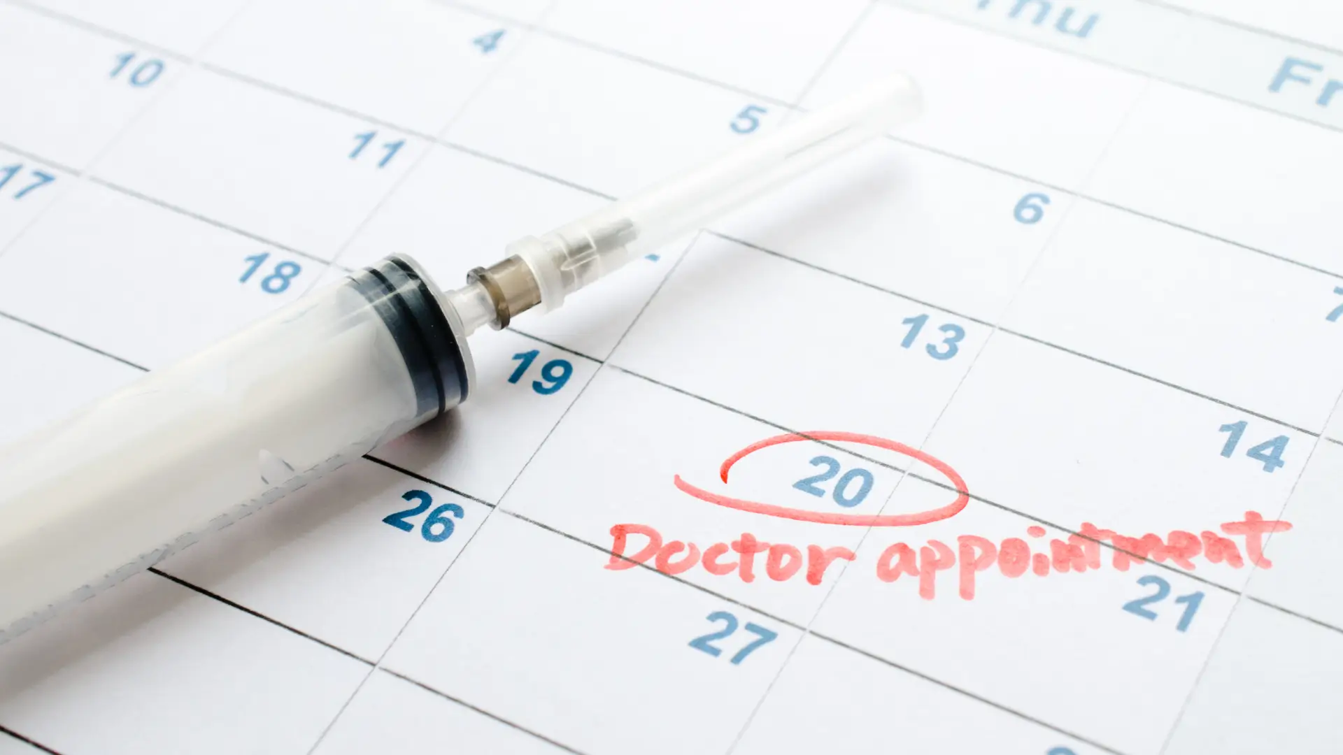 A close-up shot of an injection and a calendar.