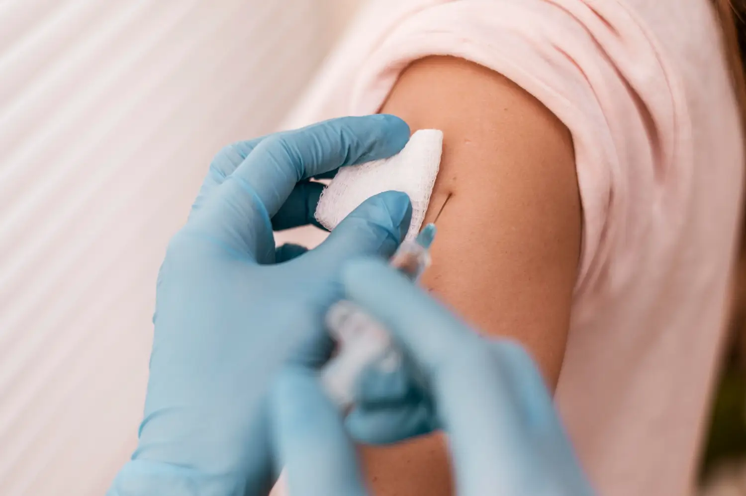 An individual receiving an injection on their upper arm.