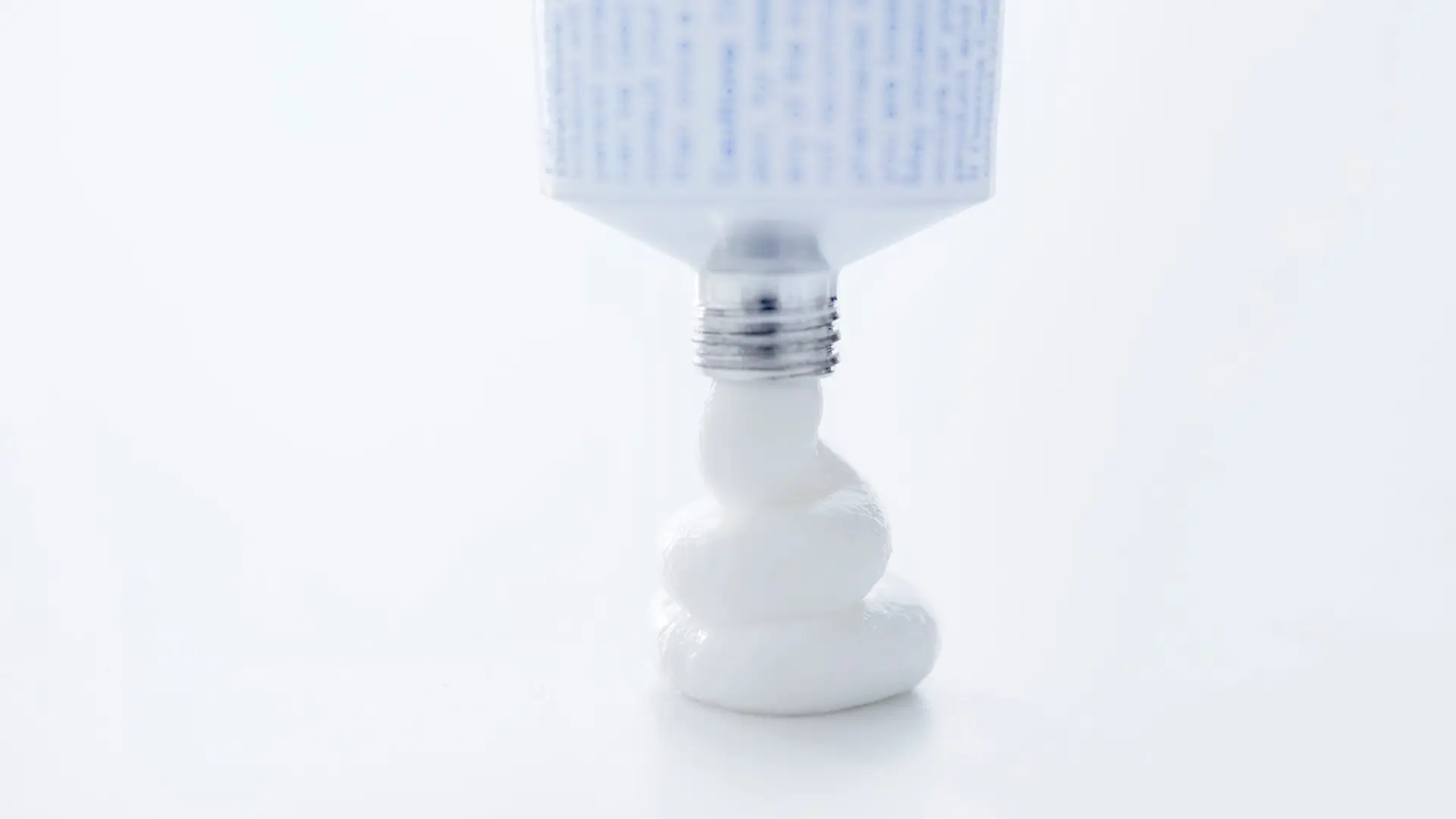 A close-up shot of cream coming from a medicine tube.