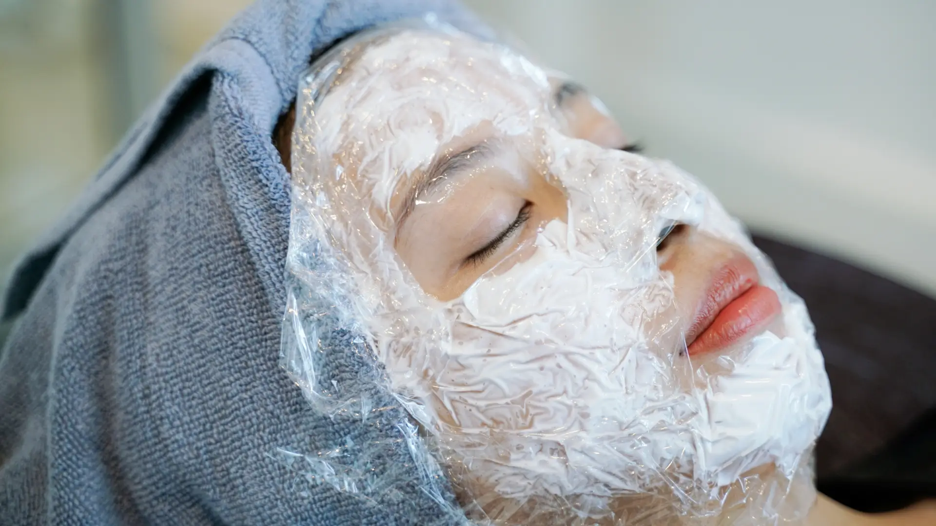 An individual with numbing cream and occlusive dressing on their facial region.