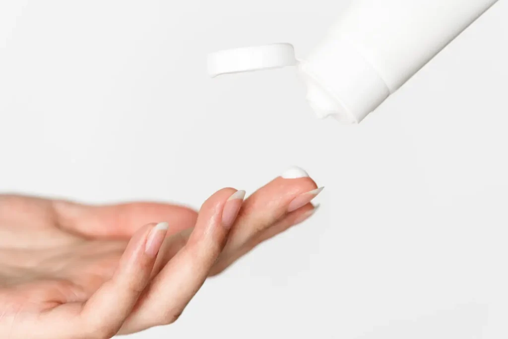 An individual preparing to apply cream on the application site.
