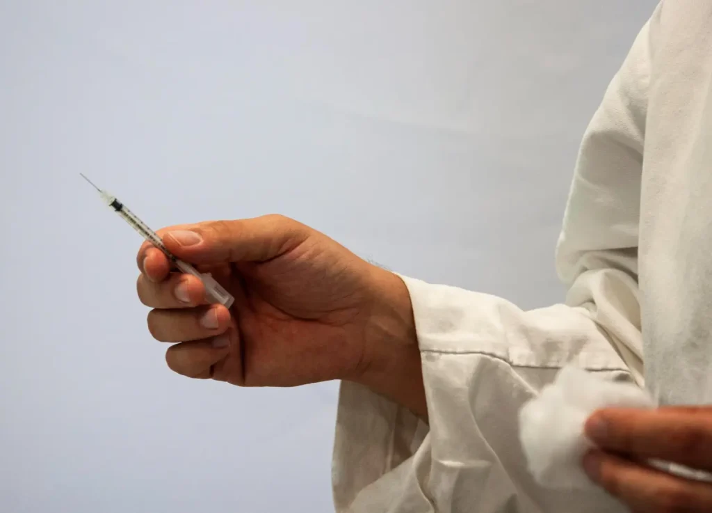 A doctor holding a injection syringe.