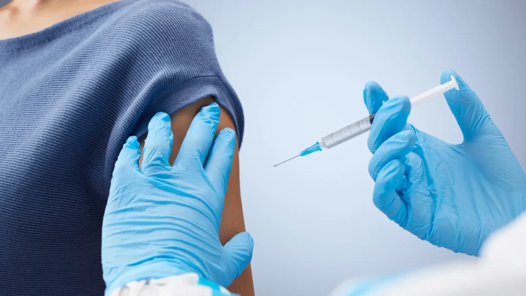 A medical professional preparing injection for their patient.