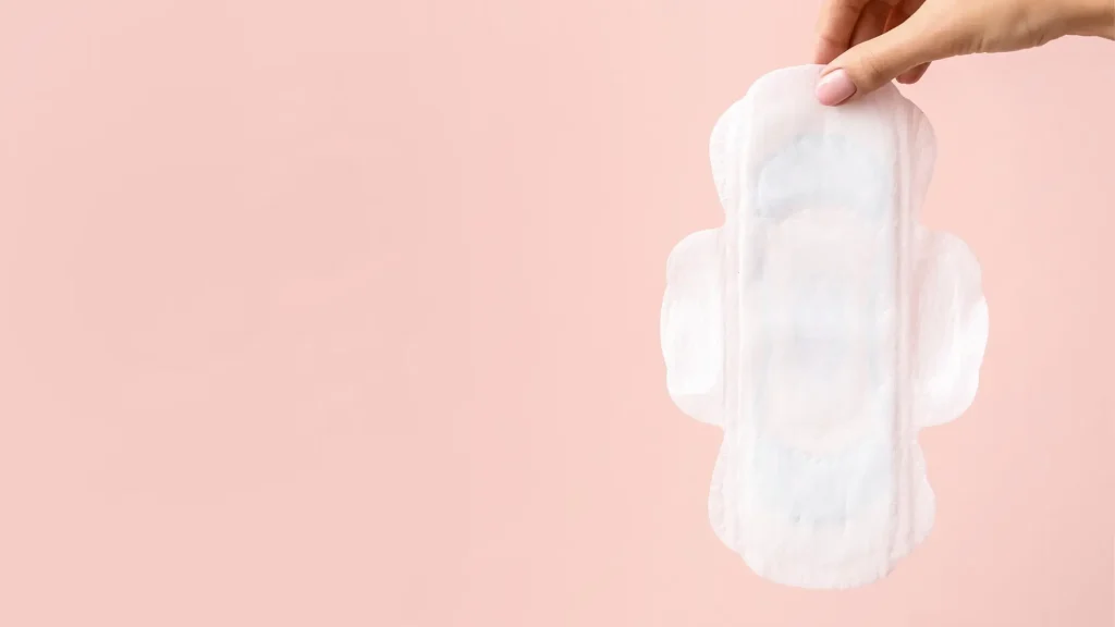 An individual holding a clean sanitary pad.