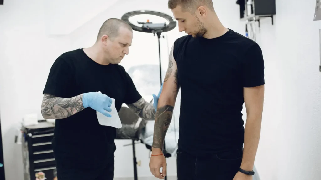 A tattoo artist preparing the client's skin before the session.