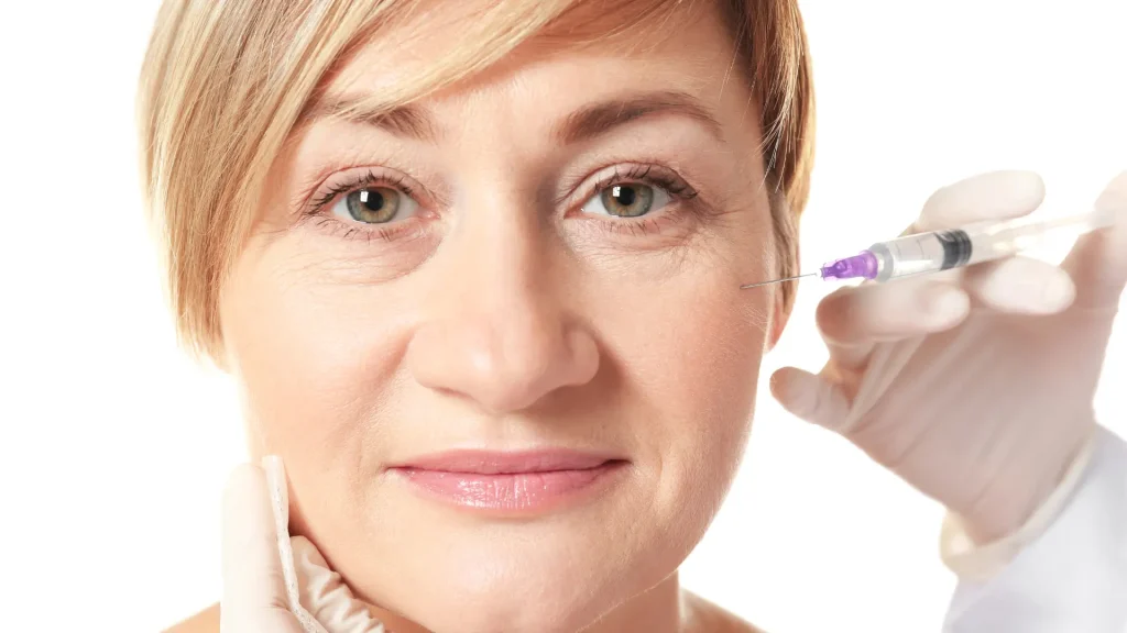 A close-up shot of an individual administering a facial injection.