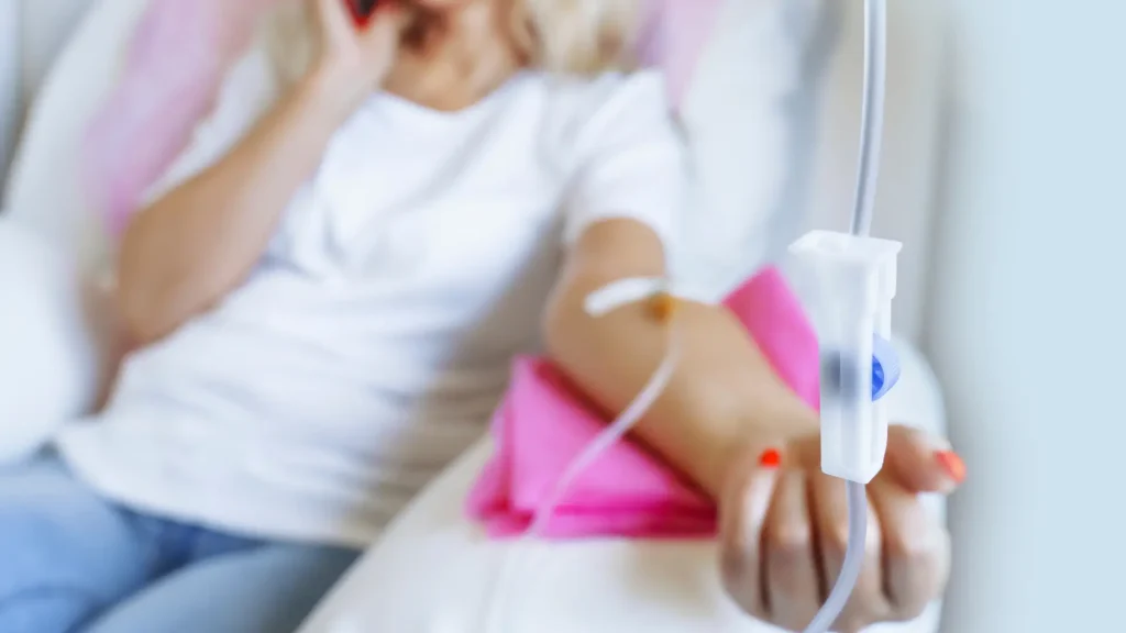 A female individual receiving an IV drip treatment.