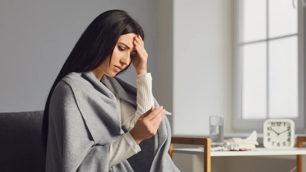 An individual dealing with symptoms, like fever, headache, and colds.