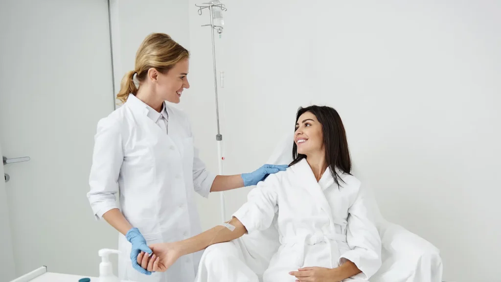 An individual receiving an IV drip from a healthcare professional.