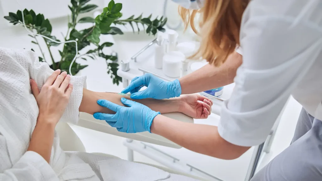 A medical professional administering an IV infusion to a patient.