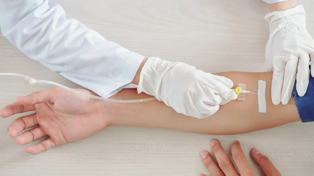 A medical professional administering an intravenous treatment.