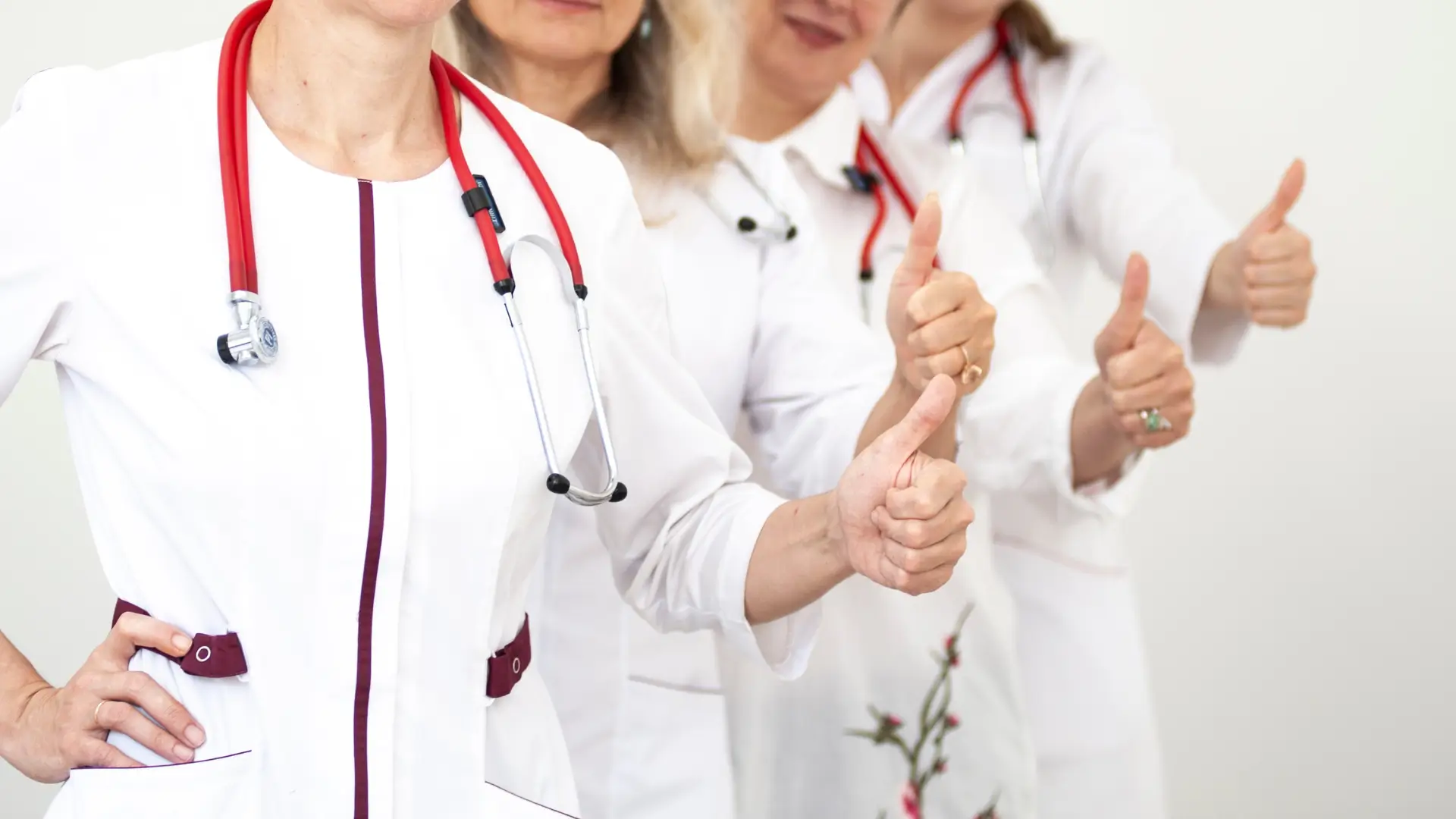 Medical professionals posing with their thumbs up.